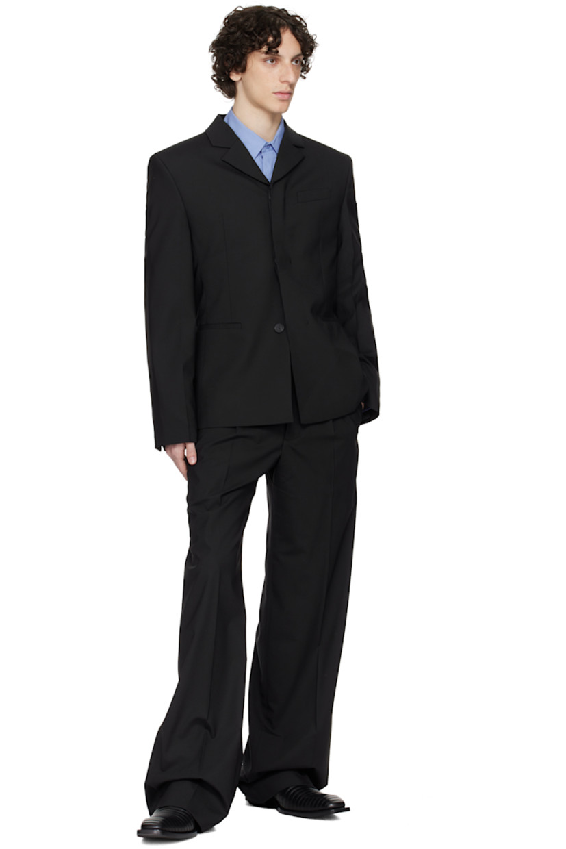 Plain-woven stretch polyester- and wool-blend blazer.

· Notched lapel
· Concealed button closure
· Welt pockets and darts at front 
· Padded shoulders
· Embroidered logo patch at sleeve
· Buttoned surgeon's cuffs
· Central vent at back hem 
· Welt pockets at interior 
· Full satin lining 

Supplier color: Black
