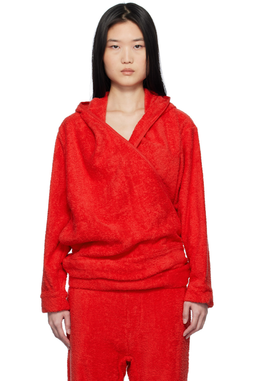 Cotton terrycloth hoodie.

· Wrap construction
· Piping at hood, V-neck, and placket
· Seam pockets
· Self-tie strap at hem
· Logo hardware at front hem
· Dropped shoulders

Supplier color: Terrycloth red