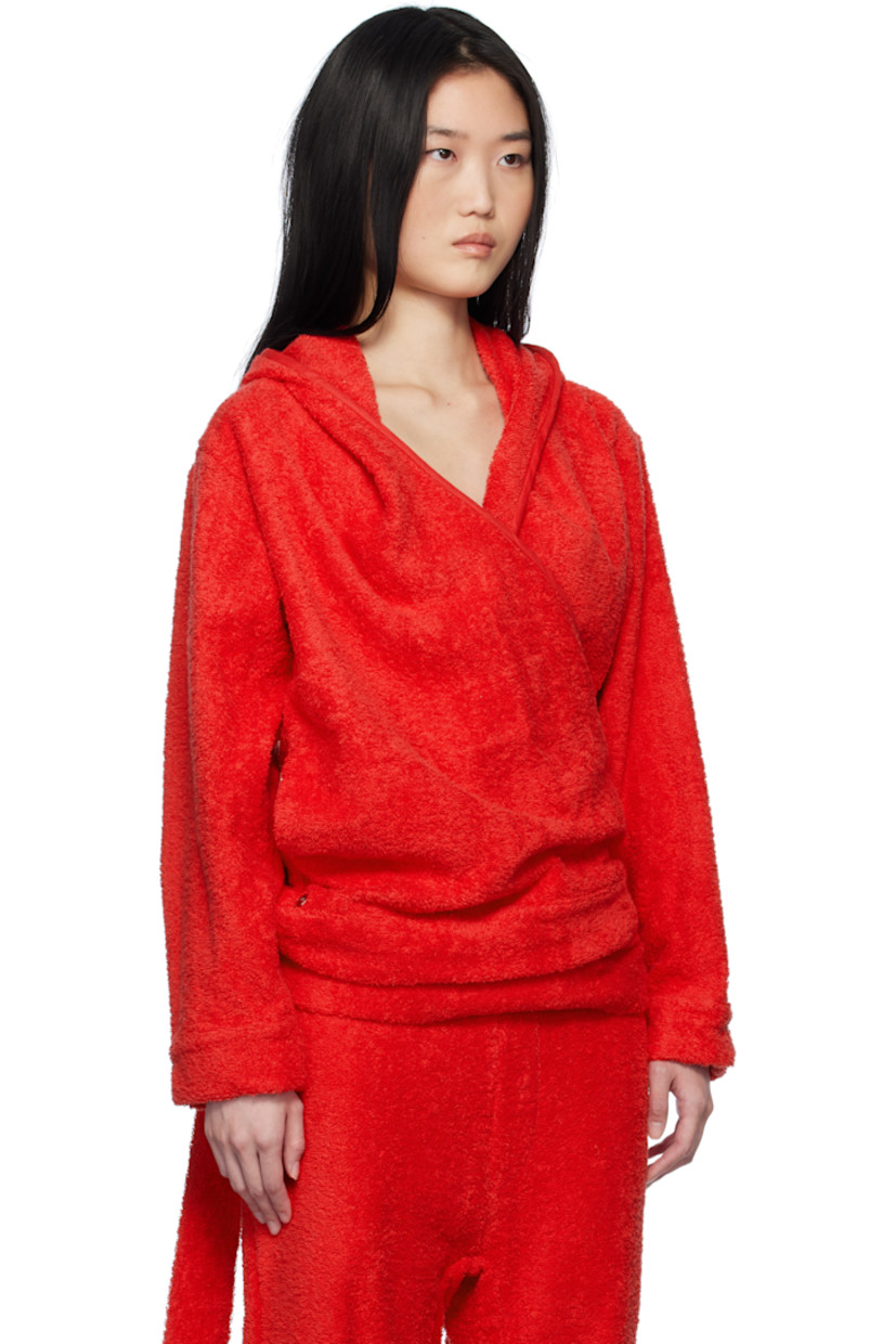 Cotton terrycloth hoodie.

· Wrap construction
· Piping at hood, V-neck, and placket
· Seam pockets
· Self-tie strap at hem
· Logo hardware at front hem
· Dropped shoulders

Supplier color: Terrycloth red