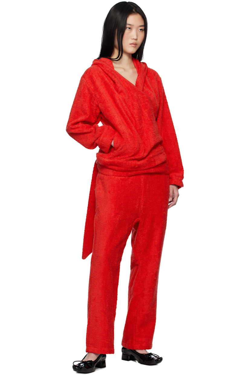 Cotton terrycloth hoodie.

· Wrap construction
· Piping at hood, V-neck, and placket
· Seam pockets
· Self-tie strap at hem
· Logo hardware at front hem
· Dropped shoulders

Supplier color: Terrycloth red