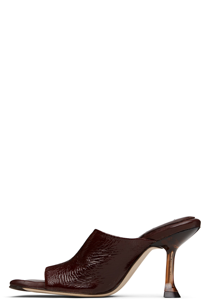 Brushed suede mules.

· Open square toe 
· Strap at vamp
· Logo patch at padded leather footbed
· Semi-transparent spool heel
· Suede sole with rubber injection
· Heel: H3.25"

Supplier color: Brown