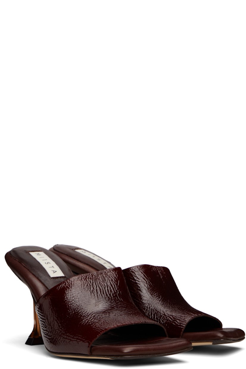 Brushed suede mules.

· Open square toe 
· Strap at vamp
· Logo patch at padded leather footbed
· Semi-transparent spool heel
· Suede sole with rubber injection
· Heel: H3.25"

Supplier color: Brown