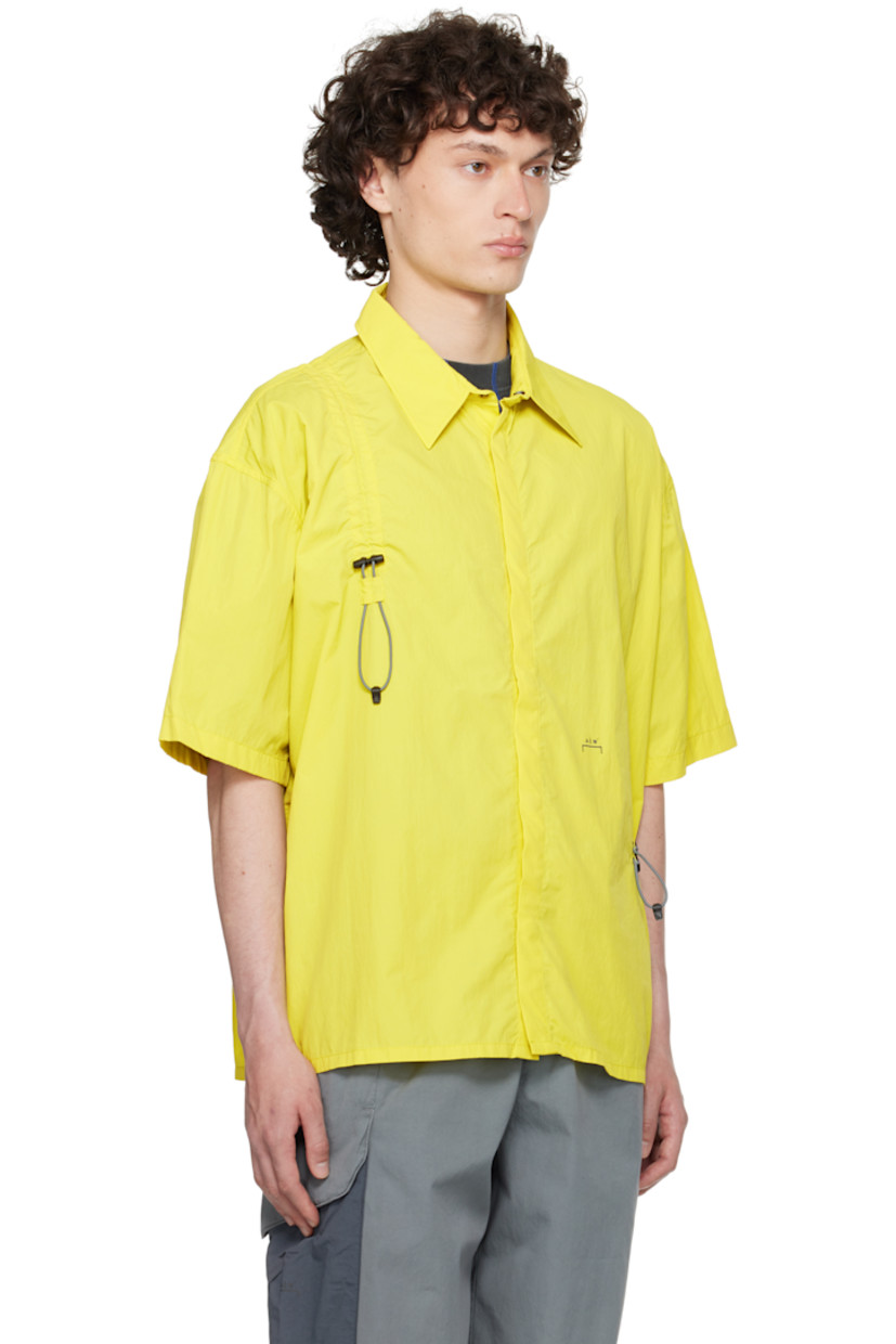 Nylon ripstop shirt.

· Spread collar
· Concealed press-stud closure
· Bungee-style drawstring extends from front to back
· Logo printed at front

Supplier color: Citronelle