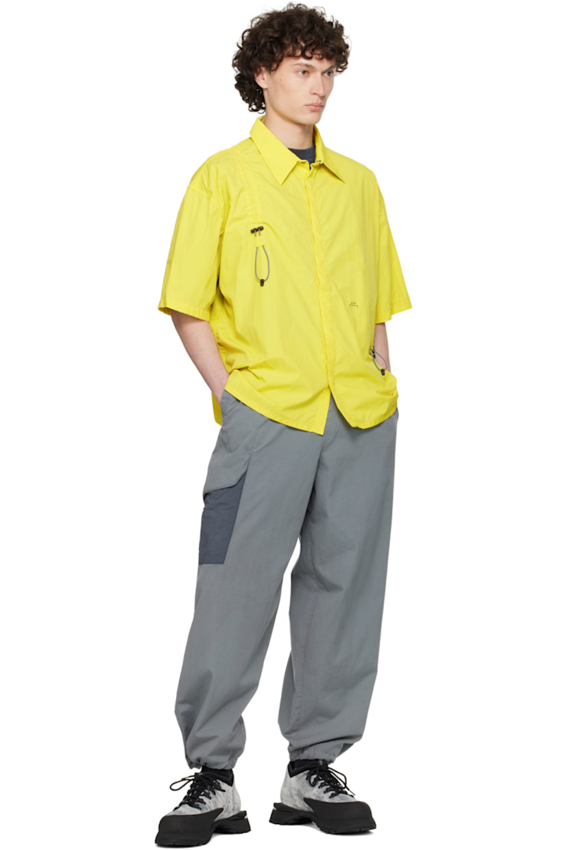 Nylon ripstop shirt.

· Spread collar
· Concealed press-stud closure
· Bungee-style drawstring extends from front to back
· Logo printed at front

Supplier color: Citronelle