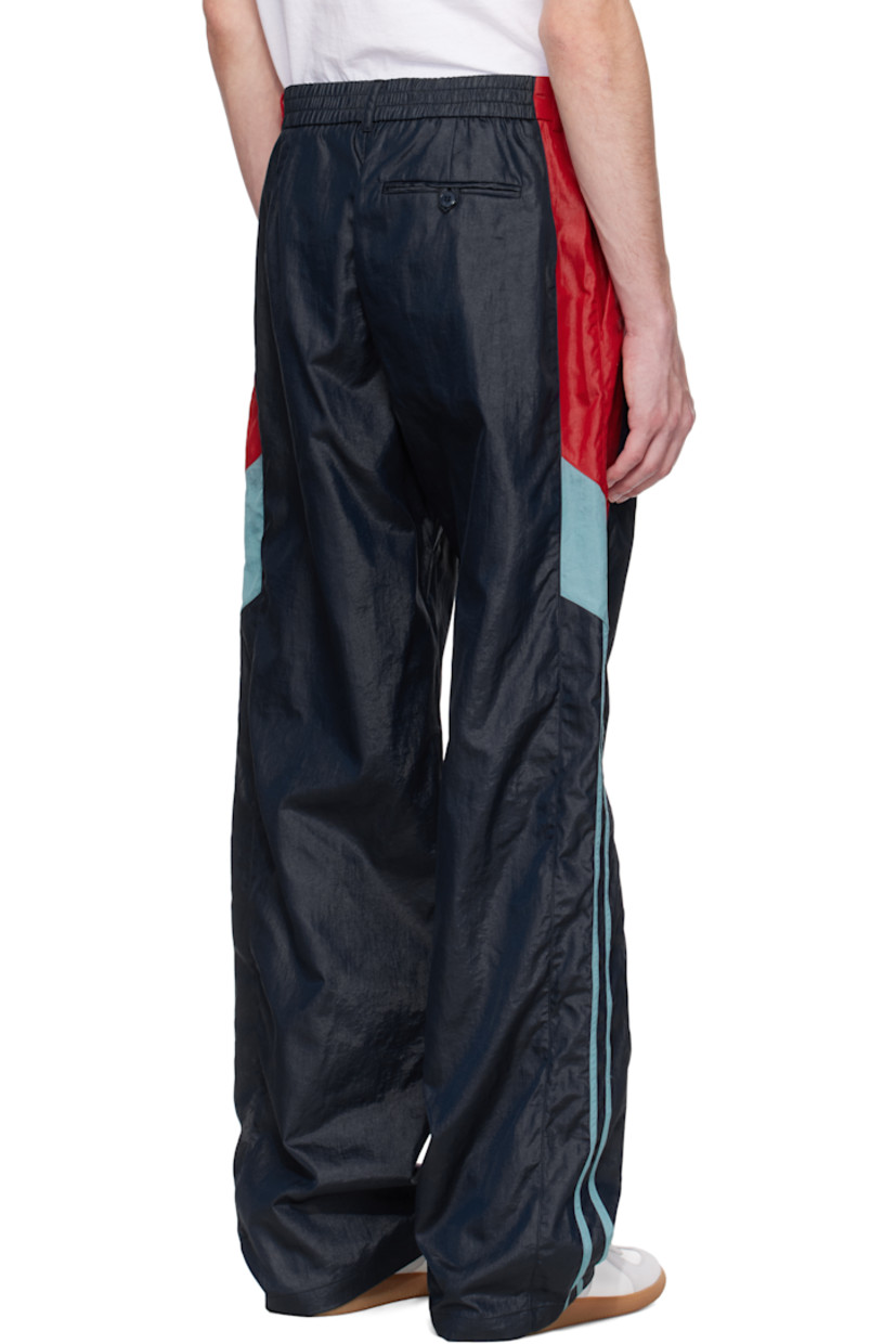 Nylon taffeta track pants. 

· Paneled construction
· Belt loops at partially elasticized waistband
· Three-pocket styling
· Zip fly
· Logo embroidered at leg
· Striped trim at outseams 

Supplier color: Blue