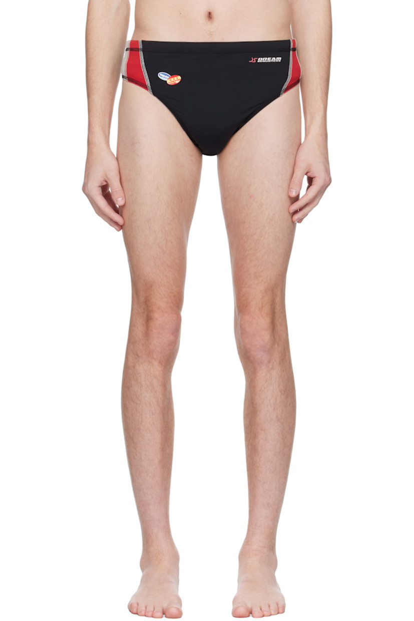 Stretch nylon jersey swim briefs.

· Concealed drawstring at elasticized waistband
· Text, graphic, and logo bonded at front and back
· Stripes at sides
· Contrast stitching in white 

Supplier color: Blk