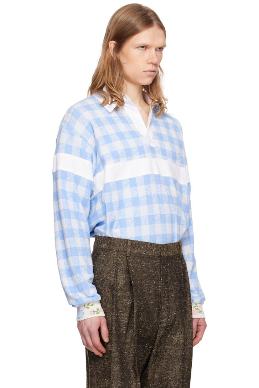 Loose-fit polyester- and cotton-blend terrycloth polo. Gingham pattern throughout.

· Spread collar
· Open placket
· Panel at chest, sleeves, and back
· Dropped shoulders
· Jacquard floral pattern at rib-knit cuffs
· Scalloped edge at cuffs

Supplier color: Baby blue