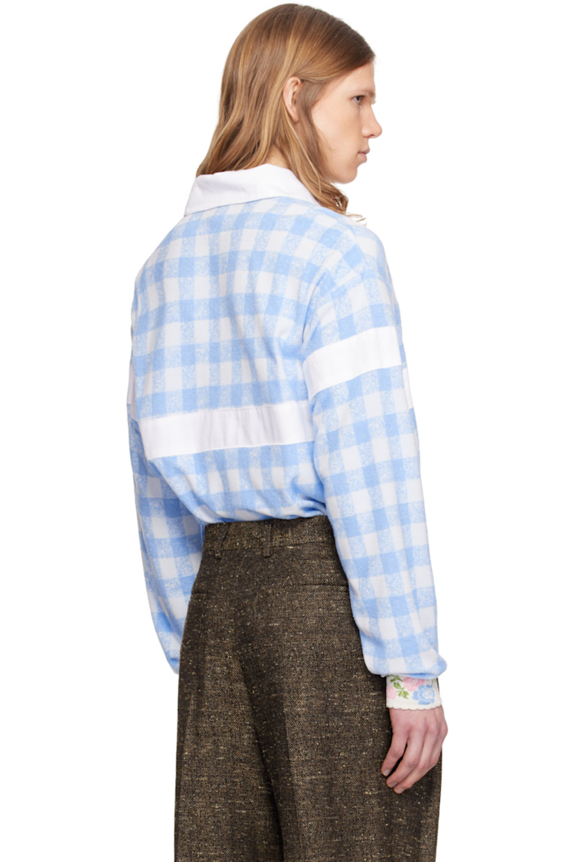 Loose-fit polyester- and cotton-blend terrycloth polo. Gingham pattern throughout.

· Spread collar
· Open placket
· Panel at chest, sleeves, and back
· Dropped shoulders
· Jacquard floral pattern at rib-knit cuffs
· Scalloped edge at cuffs

Supplier color: Baby blue