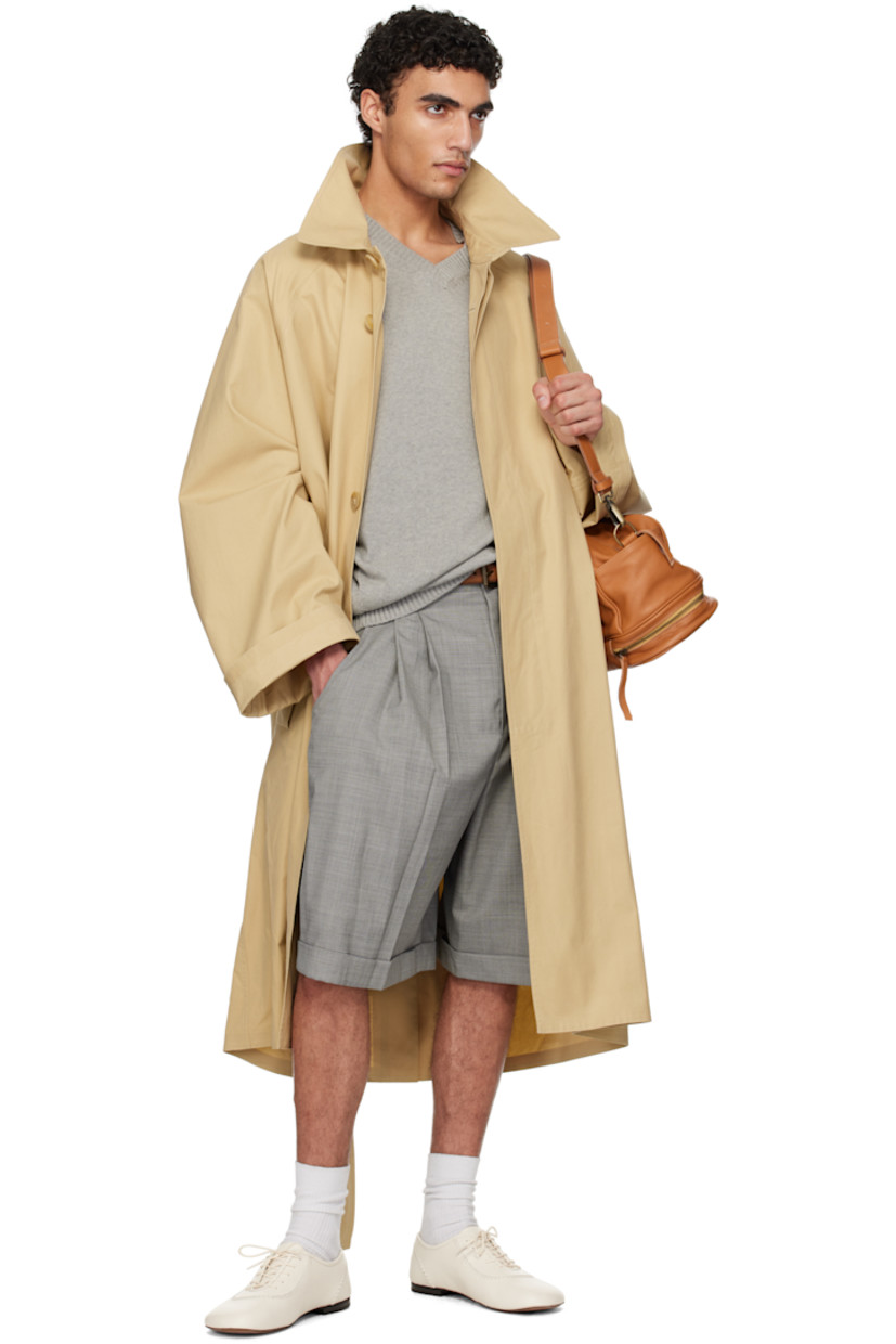 Cotton canvas trench coat.

· Spread collar
· Button closure
· Welt pockets
· Pin-buckle belt and belt loops 
· Metal grommets at underarms
· Raglan sleeves
· Central vent at back hem

Supplier color: Beige/Khaki