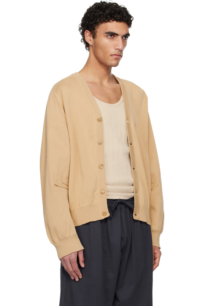 Knit cotton cardigan.

· Rib-knit Y-neck, hem, and cuffs
· Button closure
· Saddle shoulders
· Pleats at dolman sleeves

Supplier color: Medium beige
