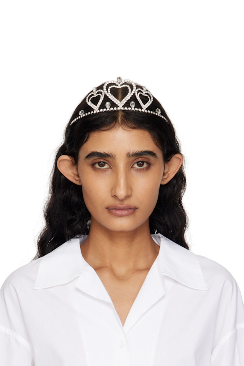 Tiara-style headband in silver-tone brass.

· Crystal-cut accents throughout
· Graphics at face
· H2.25" x W5"

Supplier color: Silver