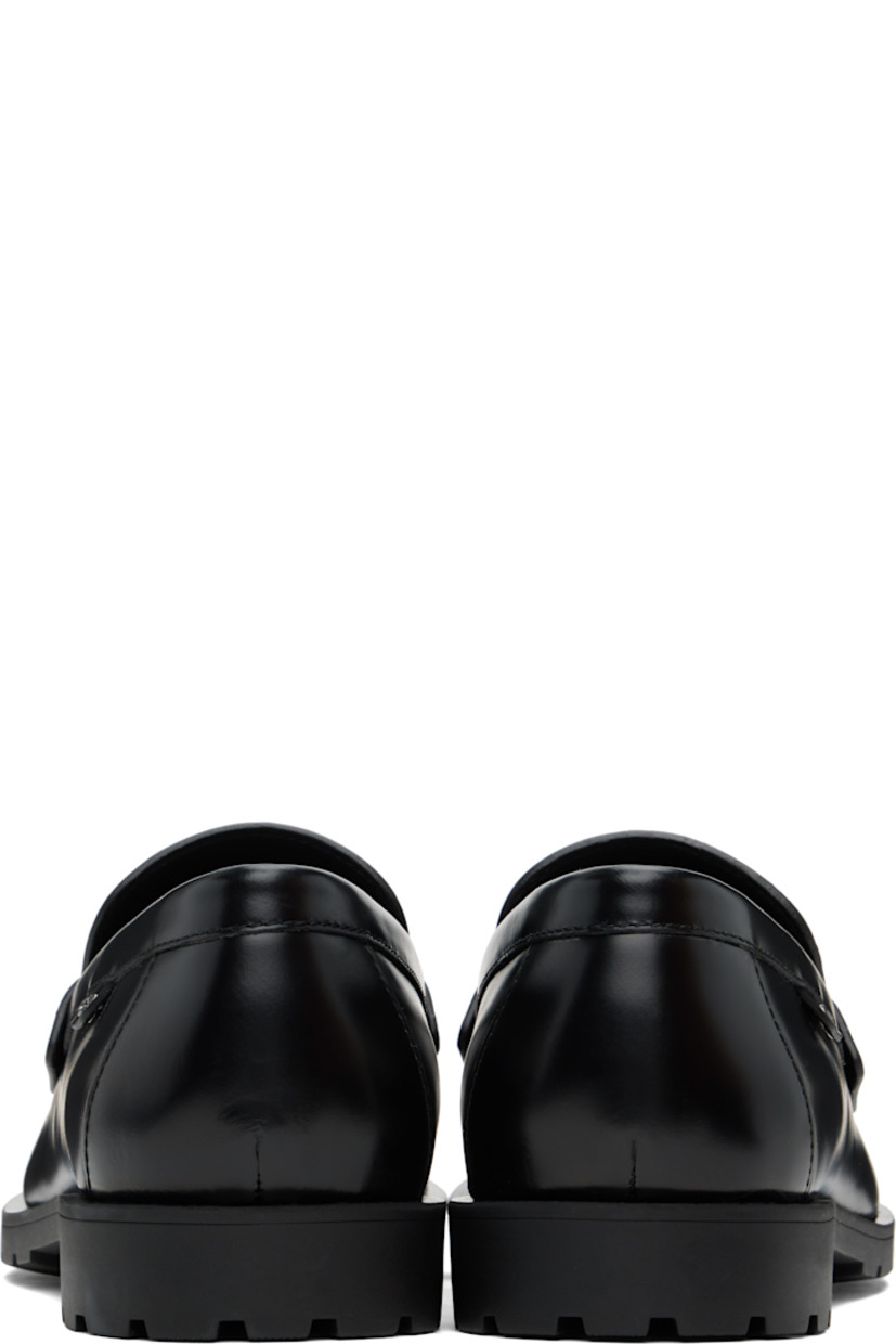 Polished leather loafers in black.

· Moc toe
· Strap with cutout at vamp
· Logo flag at outer side
· Treaded rubber sole

Supplier color: Black