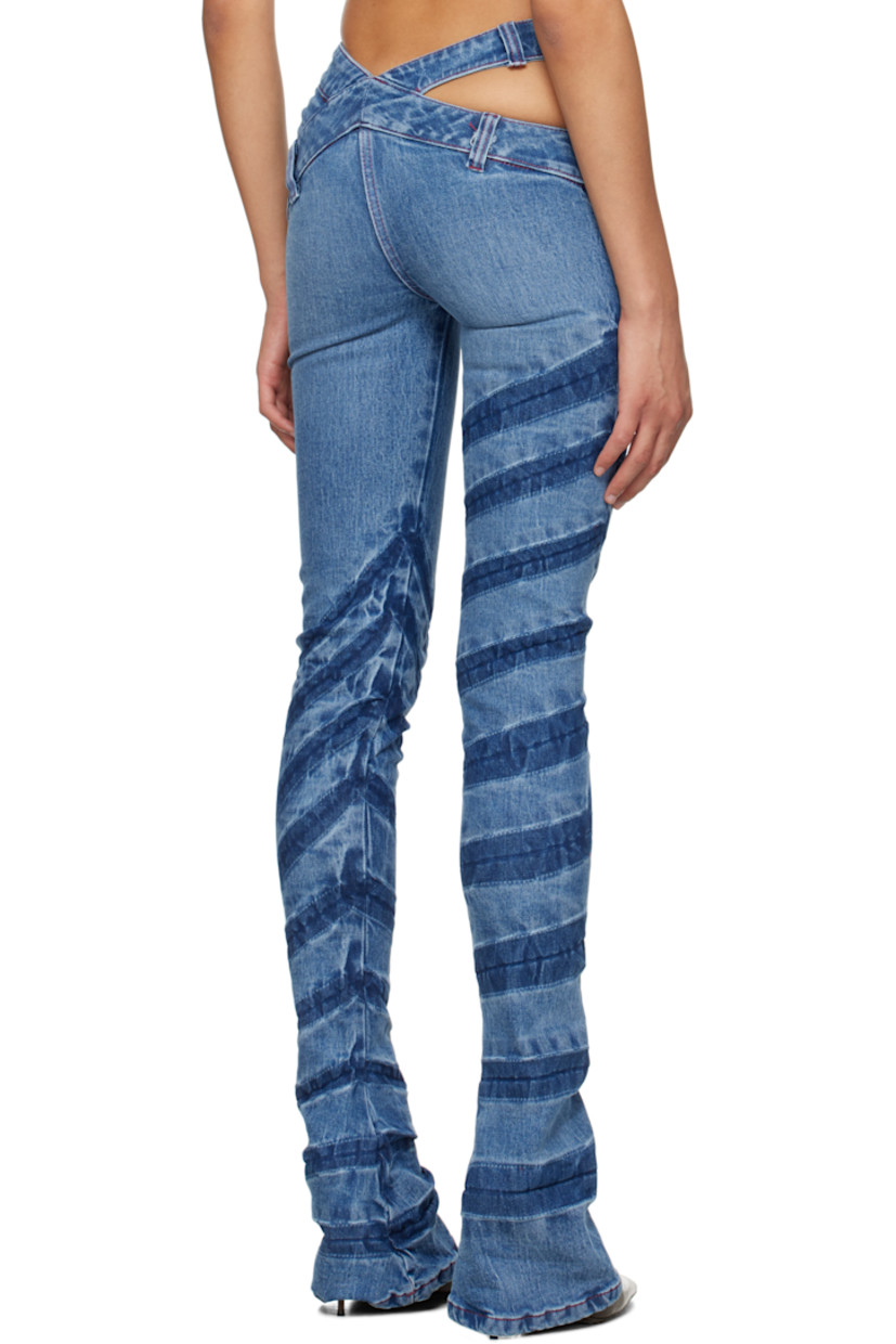 Stretch organic cotton denim jeans. Whiskering, fading, and creasing throughout. 

· Adjustable button tab at asymmetrical waistband
· Belt loops and cutout at waistband
· Single-pocket styling
· Offset zip fly
· Extended cuffs
· Contrast stitching in red

Supplier color: Blue