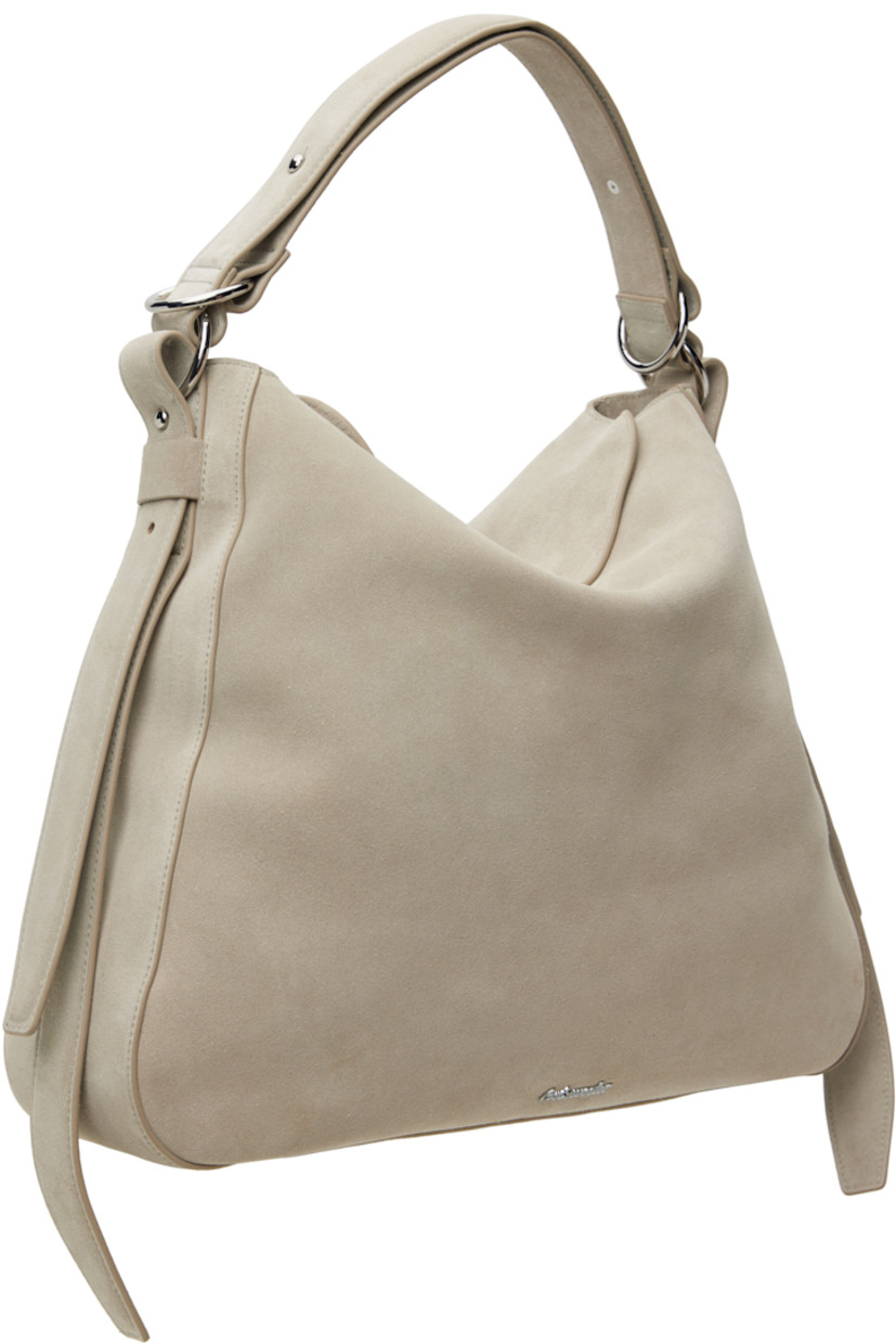 Suede shoulder bag in gray.

· Adjustable shoulder strap
· Logo hardware at face
· Adjustable and detachable post-stud strap at sides
· Magnetic flap closure
· Zip pocket at interior
· Cotton twill lining
· Silver-tone hardware
· H14.75" x W16.5" x D4.75"

Supplier color: Lt. grey