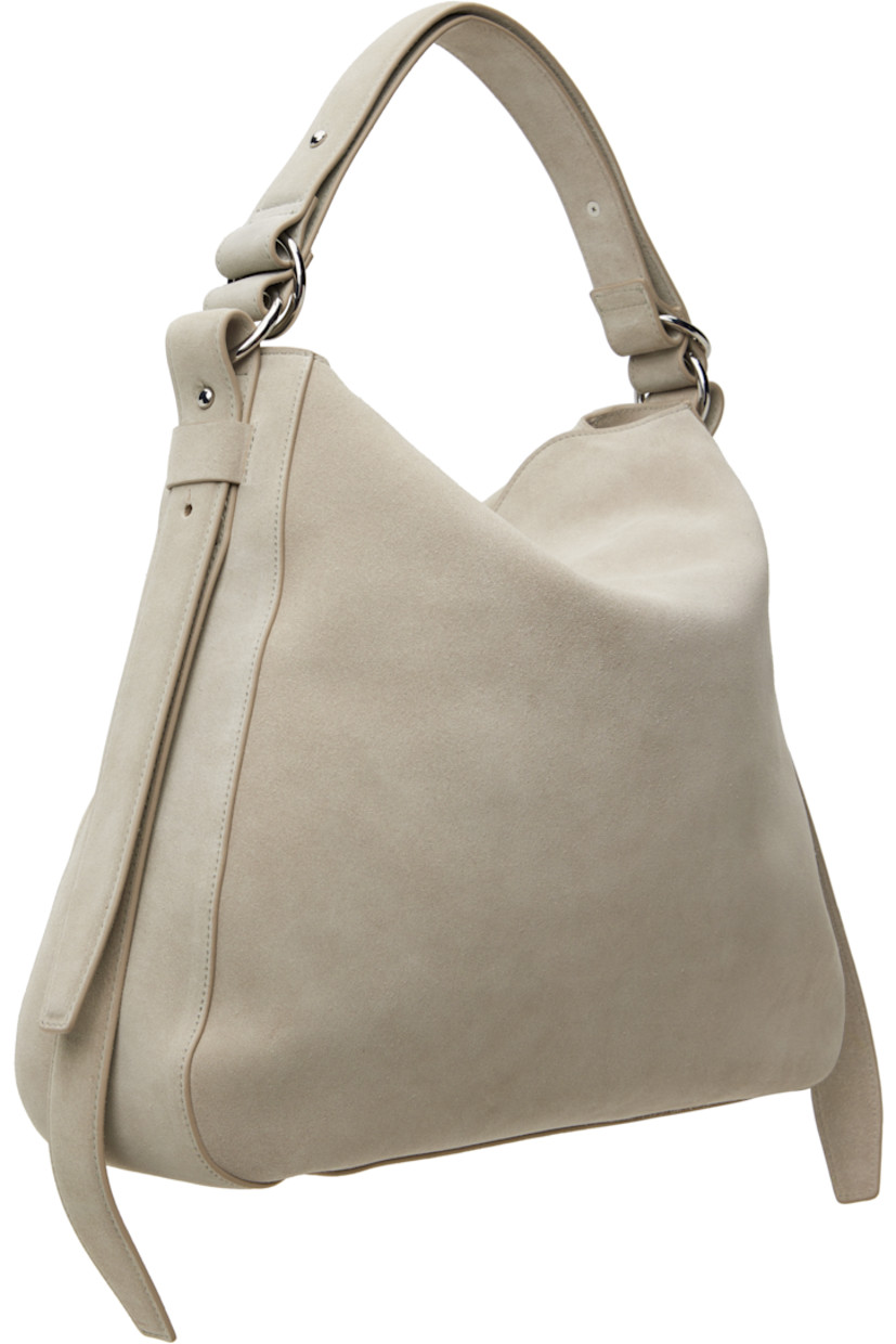 Suede shoulder bag in gray.

· Adjustable shoulder strap
· Logo hardware at face
· Adjustable and detachable post-stud strap at sides
· Magnetic flap closure
· Zip pocket at interior
· Cotton twill lining
· Silver-tone hardware
· H14.75" x W16.5" x D4.75"

Supplier color: Lt. grey