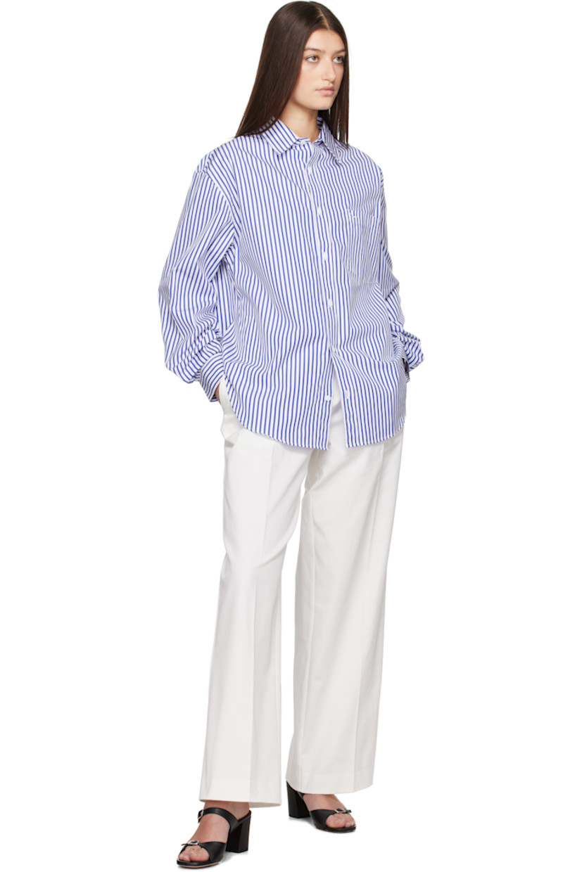 Organic cotton poplin shirt. Stripes throughout. 

· Spread collar
· Button closure
· Patch pocket at chest
· Shirttail hem
· Dropped shoulders
· Pleats at single-button barrel cuffs
· Box pleat at back yoke

Supplier color: Cobalt stripe