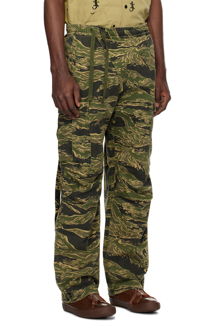 280 gsm cotton- and hemp-blend twill cargo pants. Camouflage pattern printed throughout.

· Loose-fit and tapered
· Offset drawstring at elasticized waistband
· Four-pocket styling
· Offset mock fly
· Darts at knees
· Bungee-style drawstring at cuffs
· Cargo pocket with straps at outseams

Supplier color: Mint gold