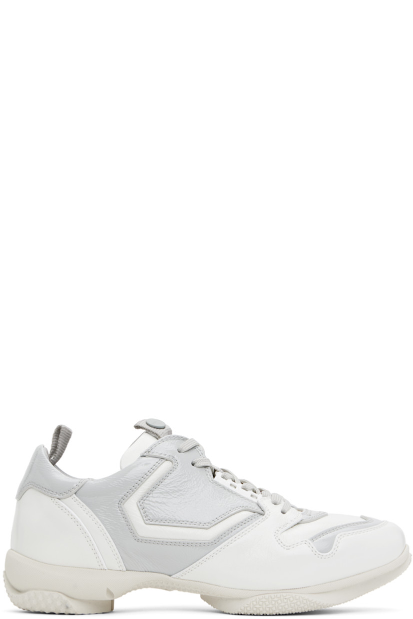 Low-top polished leather and patent calfskin sneakers in white and gray.

· Lace-up closure
· Pull-loop with logo hardware at padded tongue 
· Padded collar
· Pull-loop at heel collar
· Buffed leather and suede lining
· Treaded rubber sole

Supplier color: White brilliant
