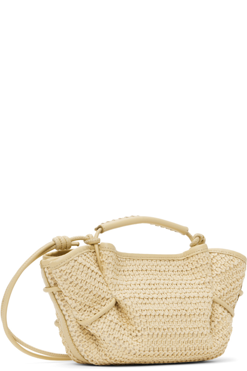 Handcrafted basket-woven raffia top handle bag in beige.

· Buffed calfskin trim throughout 
· Whipstitching at rolled carry handle
· Knotted shoulder strap
· Pleats at sides
· Magnetic closure 
· Organic cotton canvas lining 
· H5.5" x W12" x D5"

Supplier color: Natural
