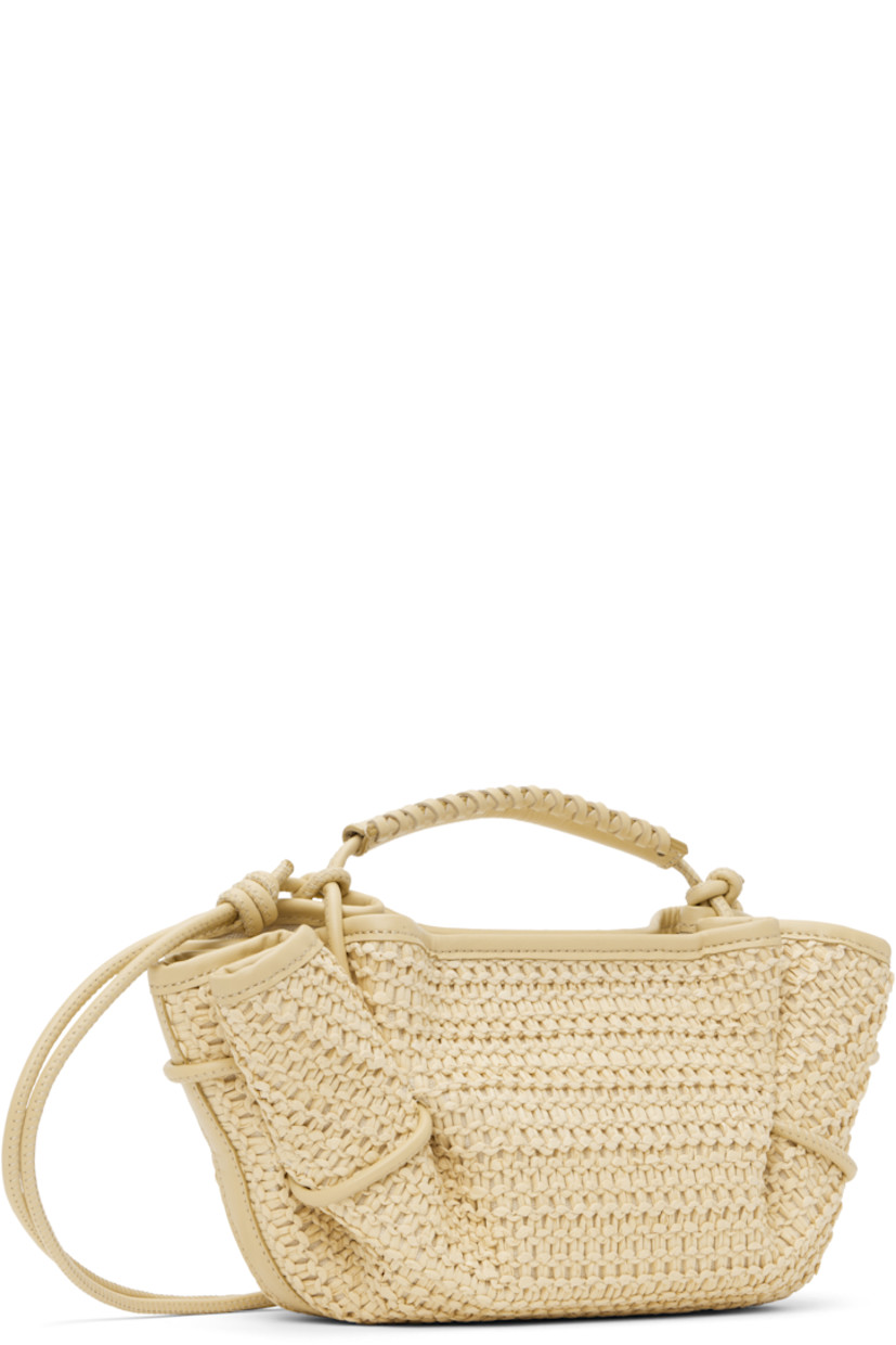 Handcrafted basket-woven raffia top handle bag in beige.

· Buffed calfskin trim throughout 
· Whipstitching at rolled carry handle
· Knotted shoulder strap
· Pleats at sides
· Magnetic closure 
· Organic cotton canvas lining 
· H5.5" x W12" x D5"

Supplier color: Natural