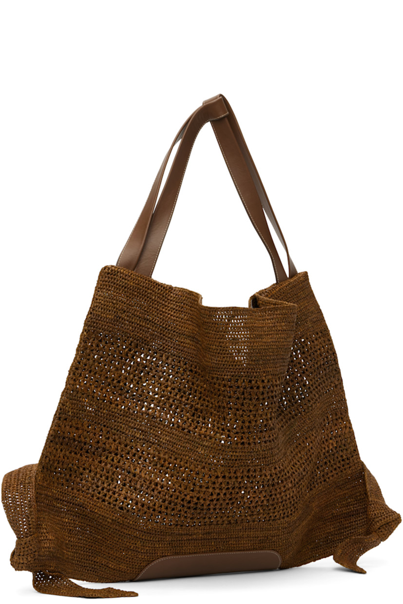 Handcrafted basket-woven raffia tote in tan.

· Buffed calfskin trim throughout
· Fixed shoulder straps
· Knotted detailing at base
· Self-tie fastening at open throat
· Unlined
· H16" x W22.5" 

Supplier color: Tan