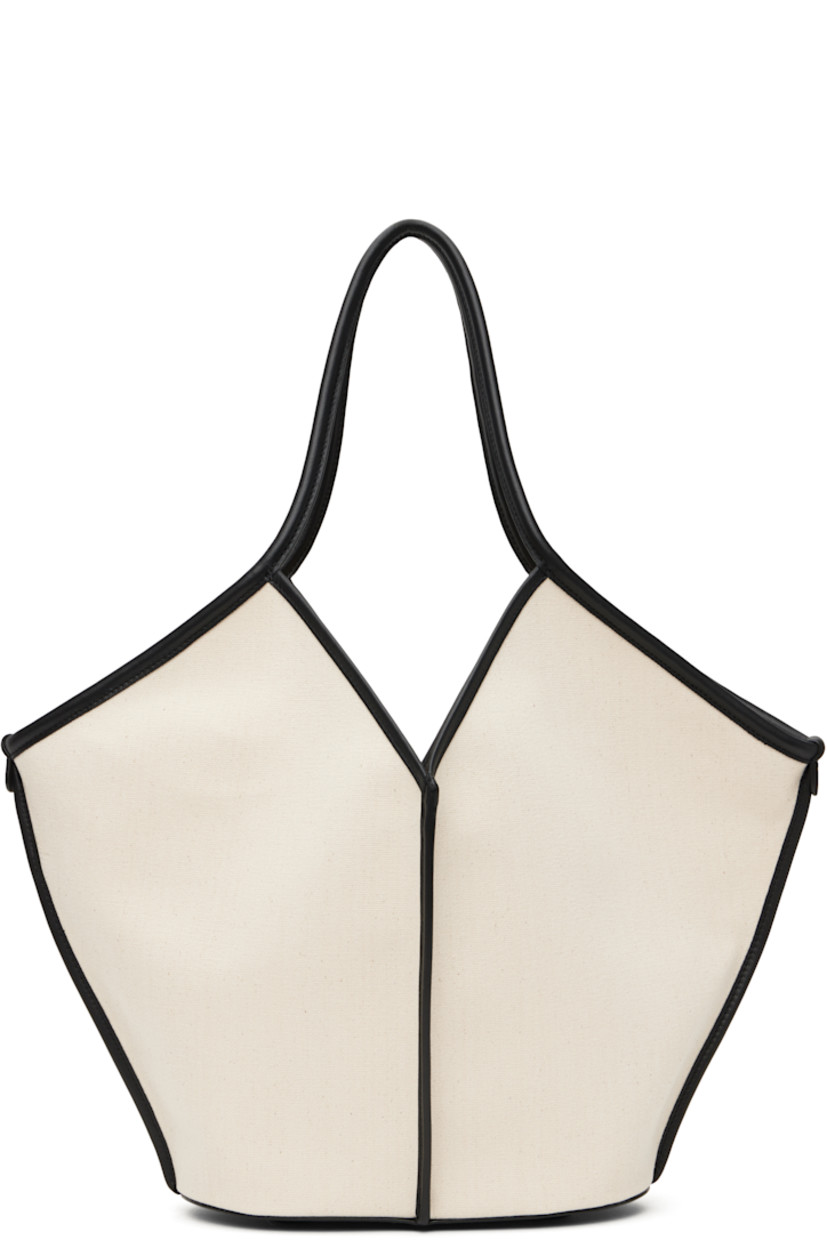 Handcrafted organic cotton canvas tote in beige and black. 

· Grained calfskin trim throughout
· Fixed twin shoulder straps
· Pinched seams at face, sides, and back face
· Bumper pads at base
· Self-tie fastening at open throat
· Detachable zip pouch at interior 
· H13" x W20" x D5"

Supplier color: Beige/Black