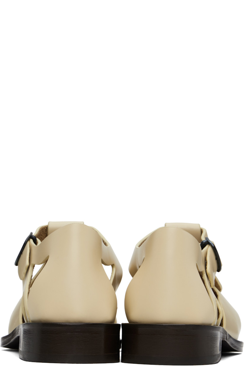 Handcrafted polished calfskin flat sandals in beige.

· Cutouts throughout
· Pin-buckle ankle strap
· Logo embossed at padded calfskin footbed
· Suede lining
· Serrated detailing at welt
· Stacked calfskin heel and midsole
· Calfskin sole with rubber injection

Supplier color: Custard