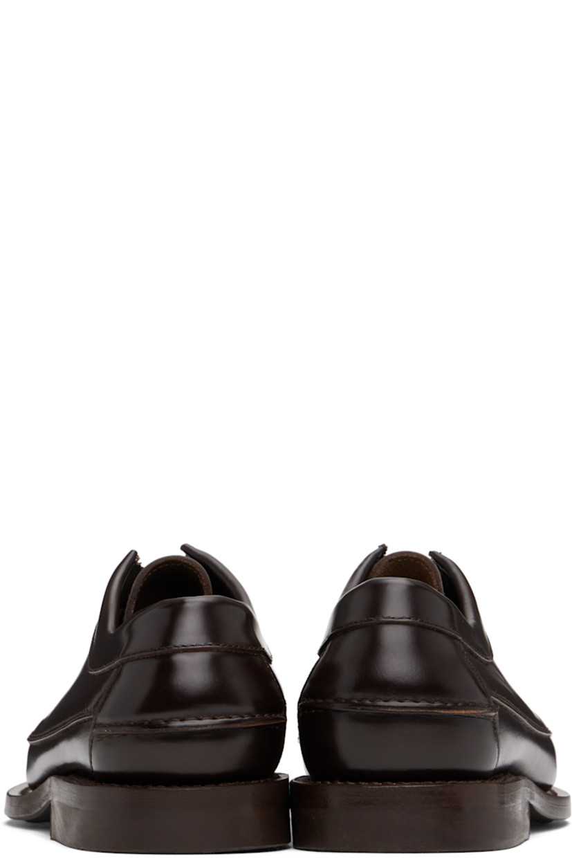 Handcrafted polished calfskin loafers in brown.

· Moc toe
· Lace-up closure
· Pinched seam at heel counter
· Logo-embossed padded leather footbed
· Grained calfskin lining
· Stacked leather heel with rubber injection
· Calfskin sole
· Heel: H1"

Supplier color: Dark brown