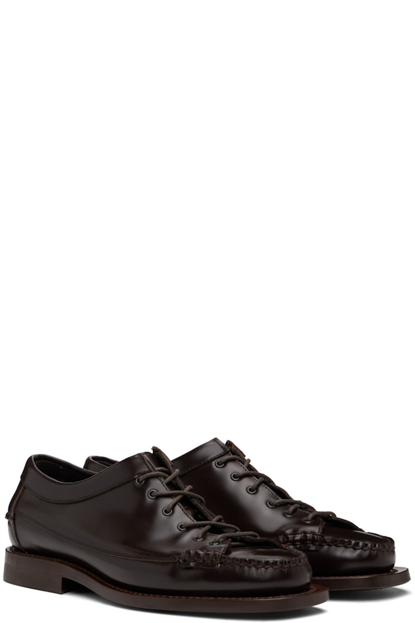 Handcrafted polished calfskin loafers in brown.

· Moc toe
· Lace-up closure
· Pinched seam at heel counter
· Logo-embossed padded leather footbed
· Grained calfskin lining
· Stacked leather heel with rubber injection
· Calfskin sole
· Heel: H1"

Supplier color: Dark brown