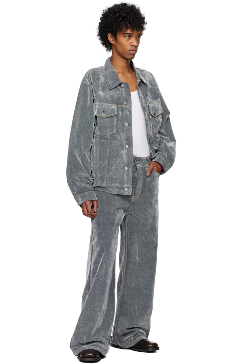 Flocked non-stretch denim jacket. 

· Spread collar 
· Button closure
· Flap pockets
· Welt pockets
· Pleat at single-button barrel cuffs
· Adjustable button tabs and logo patch at back hem
· Contrast stitching in tan 

Supplier color: Grey flock