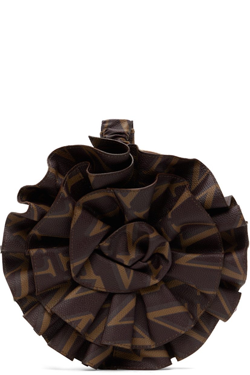 Grained faux-leather pouch in brown.

· Logo pattern printed throughout
· Adjustable and partially elasticized wristlet
· Floral appliqué at face
· Zip closure
· Cotton twill lining
· Gold-tone hardware
· H8" x W8" x D2"

Supplier color: Brown
