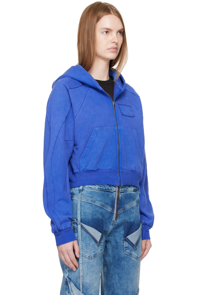 Organic cotton fleece hoodie. 

· Zip closure
· Patch with raw edge at chest
· Patch pockets
· Rib-knit cropped hem and cuffs
· Raglan sleeves
· Graphic printed at back 

Supplier color: Surf blue