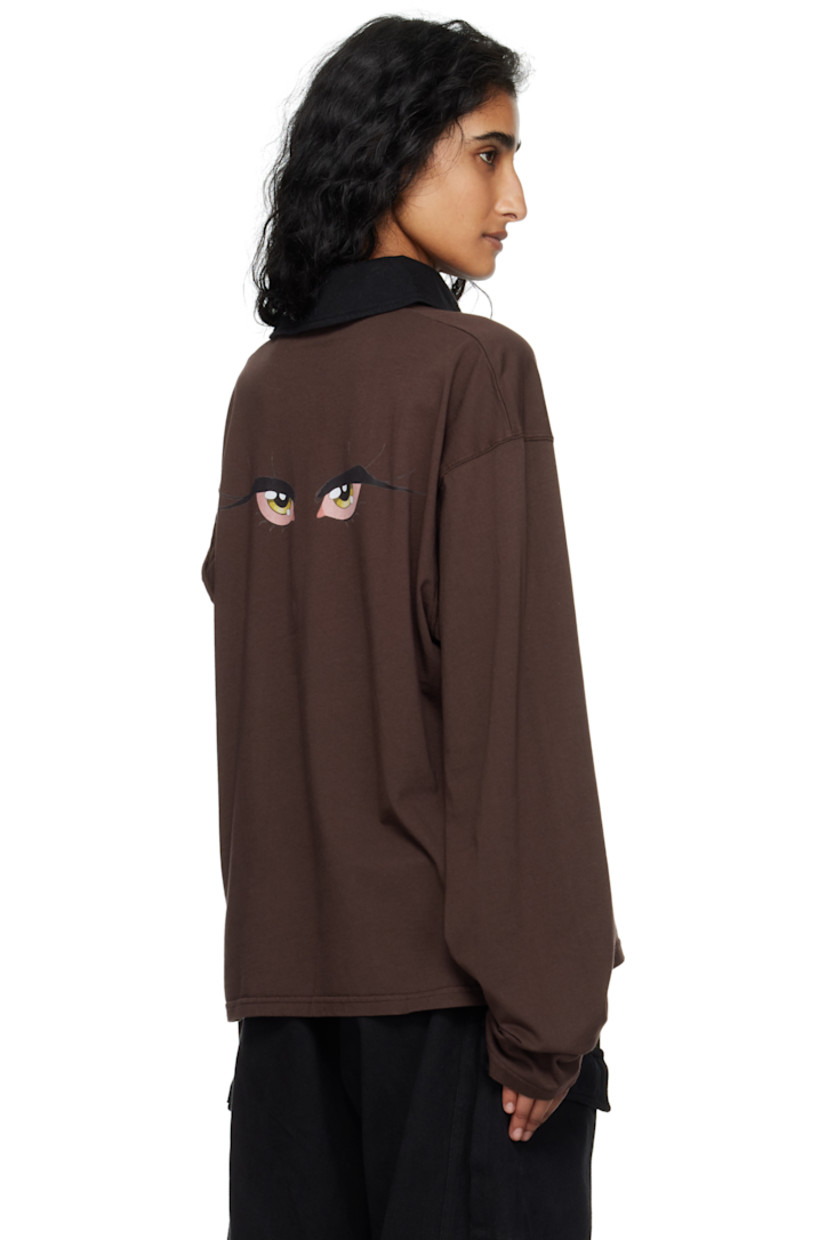 Organic cotton jersey polo.

· Spread collar
· Four-button placket
· Logo embroidered at chest
· Dropped shoulders
· Extended trim at sleeve
· Graphic printed at back

Featuring artwork from Julien Ceccaldi.

Supplier color: Dark brown wash