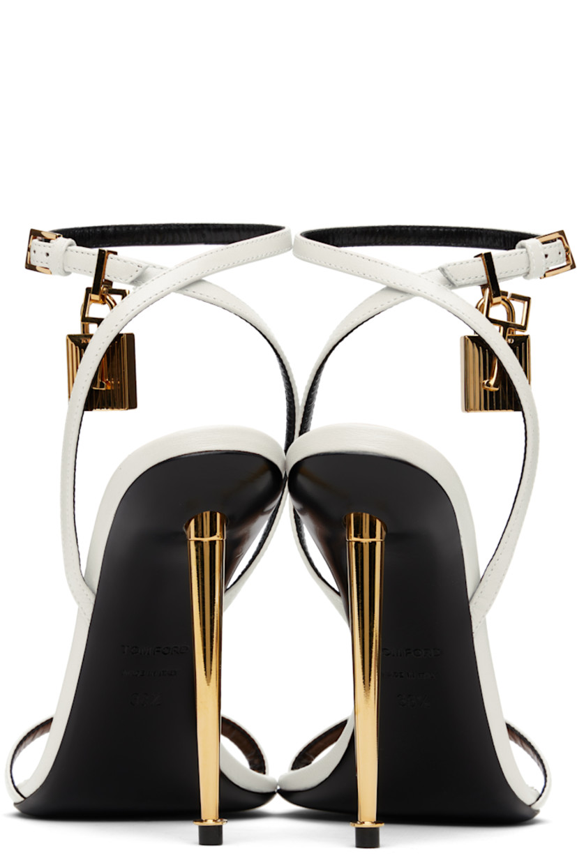 Buffed goatskin heeled sandals.

· Open pointed toe
· Padlock and logo charm at pin-buckle ankle strap
· Logo printed at leather footbed
· Metal stiletto heel with rubber injection
· Polished leather sole
· Logo-engraved gold-tone hardware
· Heel: H4.25"

Supplier color: Chalk