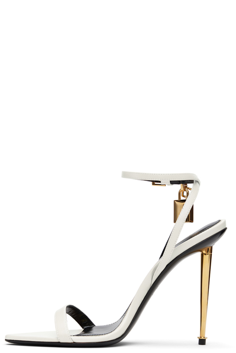 Buffed goatskin heeled sandals.

· Open pointed toe
· Padlock and logo charm at pin-buckle ankle strap
· Logo printed at leather footbed
· Metal stiletto heel with rubber injection
· Polished leather sole
· Logo-engraved gold-tone hardware
· Heel: H4.25"

Supplier color: Chalk