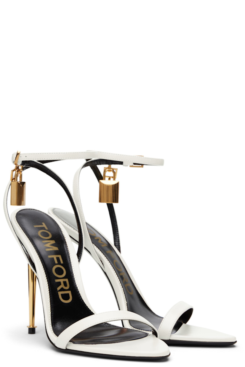 Buffed goatskin heeled sandals.

· Open pointed toe
· Padlock and logo charm at pin-buckle ankle strap
· Logo printed at leather footbed
· Metal stiletto heel with rubber injection
· Polished leather sole
· Logo-engraved gold-tone hardware
· Heel: H4.25"

Supplier color: Chalk
