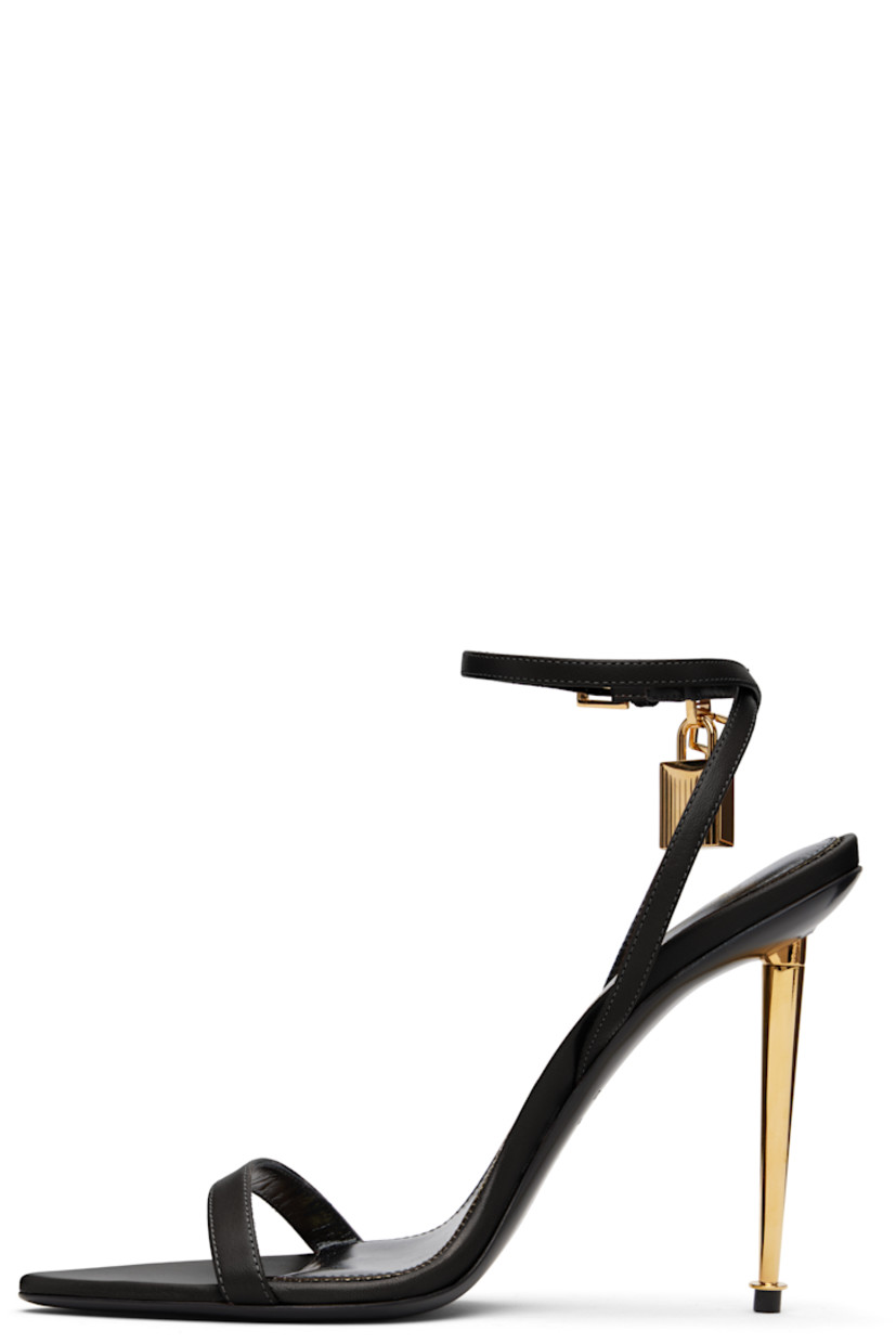 Buffed goatskin heeled sandals.

· Open pointed toe
· Padlock and logo charm at pin-buckle ankle strap
· Logo printed at leather footbed
· Metal stiletto heel with rubber injection
· Polished leather sole
· Logo-engraved gold-tone hardware
· Heel: H4.25"

Supplier color: Black