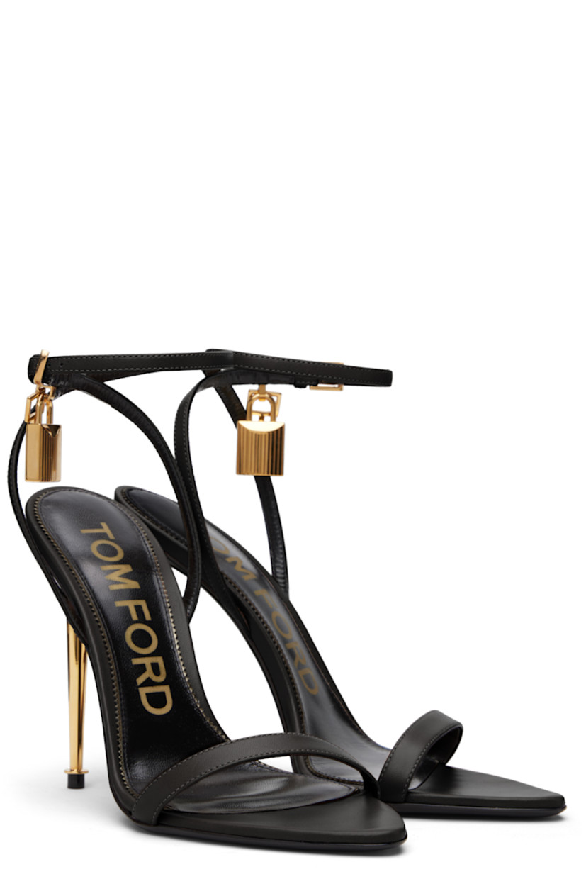 Buffed goatskin heeled sandals.

· Open pointed toe
· Padlock and logo charm at pin-buckle ankle strap
· Logo printed at leather footbed
· Metal stiletto heel with rubber injection
· Polished leather sole
· Logo-engraved gold-tone hardware
· Heel: H4.25"

Supplier color: Black