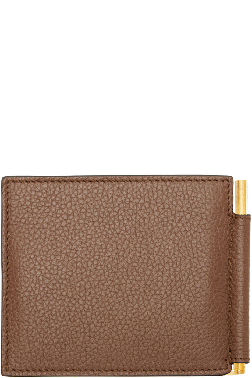Grained leather bifold wallet.

· Logo stamp at face
· Eight card slots 
· Logo-engraved money clip at interior
· Leather interior
· Textile lining
· H3.5" x W4.5"

Supplier color: Mid brown