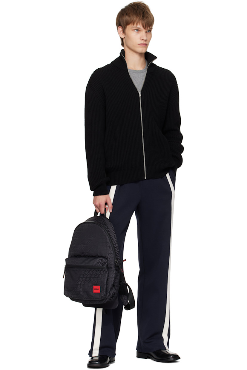 Taffeta backpack.

· Jacquard logo pattern throughout
· Fixed carry handle
· Adjustable padded shoulder straps
· Rubberized logo patch and zip pocket at face
· D-ring at sides
· Padded panel at back face
· Two-way zip closure
· Zip pocket and laptop compartment at interior
· H16.5" x W14" x D5.5"

Supplier color: Black