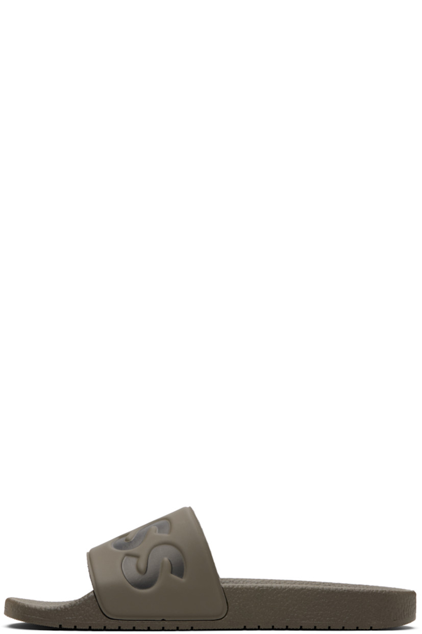 Rubber slides.

· Open toe
· Logo embossed at vamp
· Jersey lining
· Treaded rubber sole

Supplier color: Medium brown