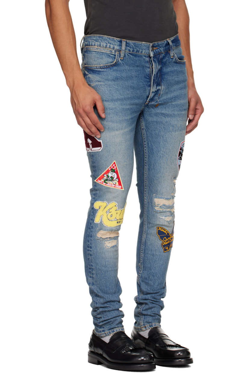 Stonewashed stretch denim jeans. 

· Skinny-fit 
· Fading, whiskering, and distressing throughout 
· Belt loops
· Five-pocket styling
· Button fly
· Graphic appliqués at legs
· Logo embroidered at back waist
· Contrast stitching in tan 

Supplier color: Denim