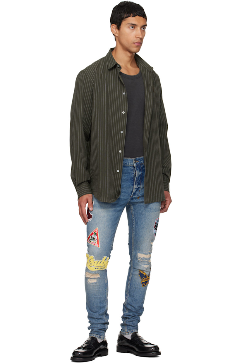 Stonewashed stretch denim jeans. 

· Skinny-fit 
· Fading, whiskering, and distressing throughout 
· Belt loops
· Five-pocket styling
· Button fly
· Graphic appliqués at legs
· Logo embroidered at back waist
· Contrast stitching in tan 

Supplier color: Denim