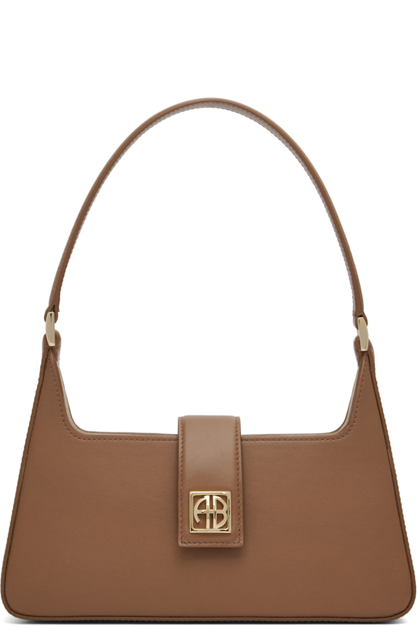 Buffed leather shoulder bag.

· Fixed shoulder strap
· Logo hardware at face
· Magnetic foldover flap
· Patch pocket at interior
· Gold-tone hardware
· H5” x W10” x D2.5”

Supplier color: Cognac