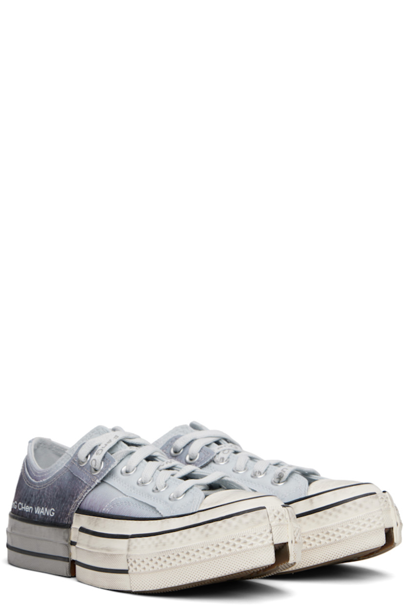 Low-top canvas sneakers. Smudging, graphic patterns, and raw edges throughout.

· Rubber cap toe
· Lace-up closure
· Logo printed at outer side
· Metal eyelet at inner side
· Modified notched rubber sole
· Includes alternate laces in gray

Part of the Feng Chen Wang x Converse collaboration.

Supplier color: Blue/Egret/Black