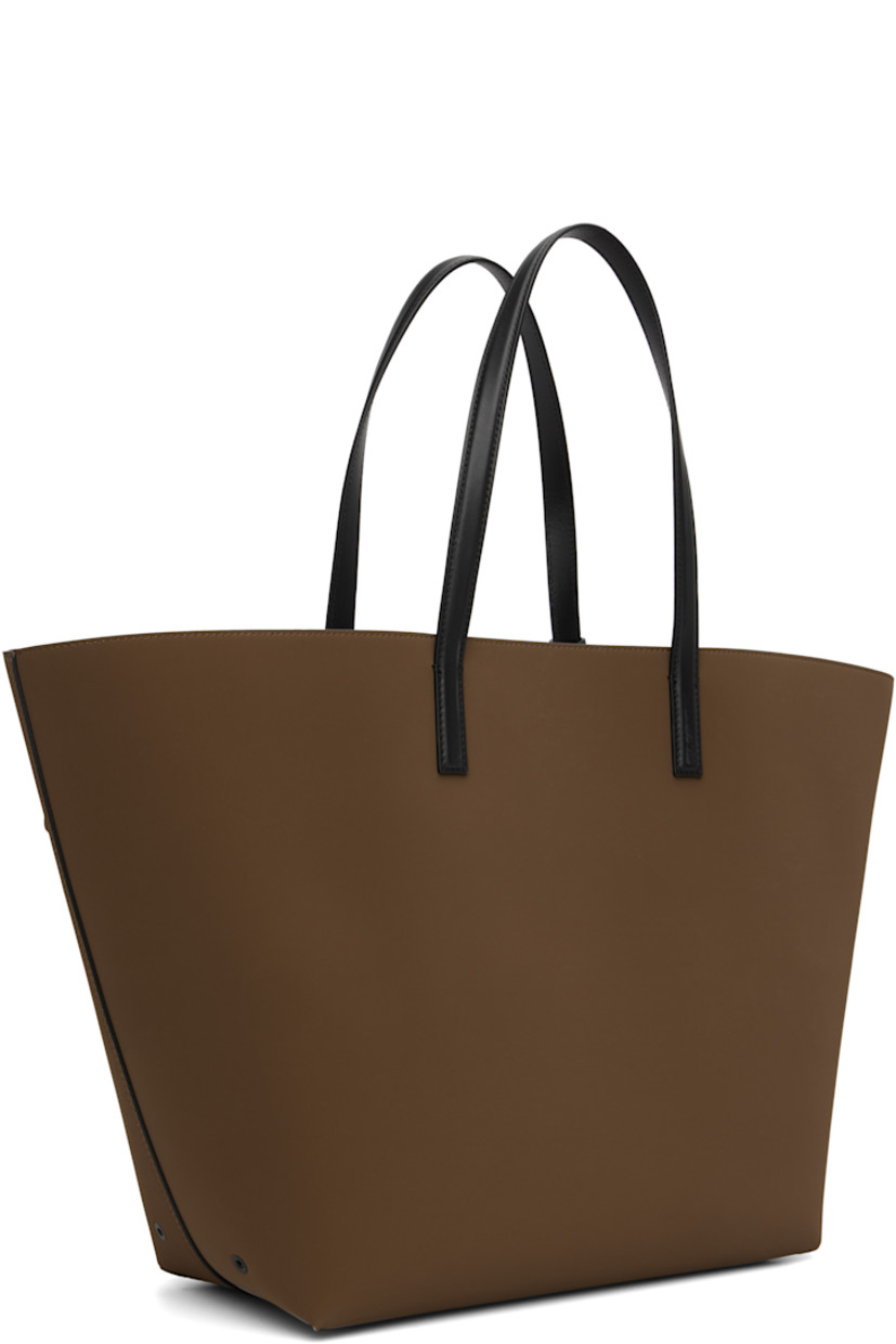 Twill tote.

· Fixed buffed calfskin shoulder straps
· Detachable zip pouch and keyring at shoulder strap
· Logo embossed at face
· Metal eyelets at sides
· Faux-suede lining
· H15" x W24" x D7"

Supplier color: Brown