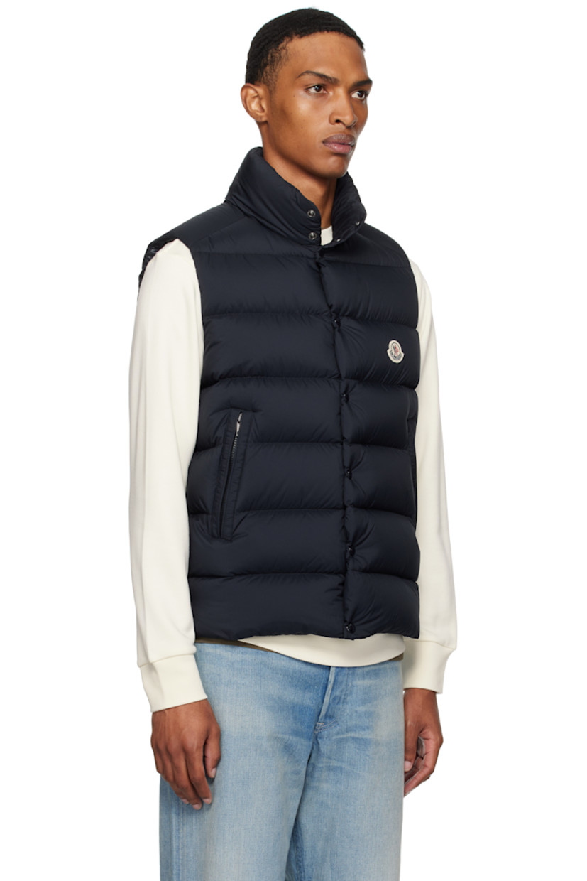 Down-filled and quilted recycled nylon longue saison vest.

· DIST-certified down
· Stand collar
· Two-way zip closure with press-stud placket
· Felted logo patch at chest
· Zip pockets
· Vented side seams
· Zip pocket at interior
· Fully lined

Supplier color: Obsidian blue

Fill: 90% goose down, 10% feather.