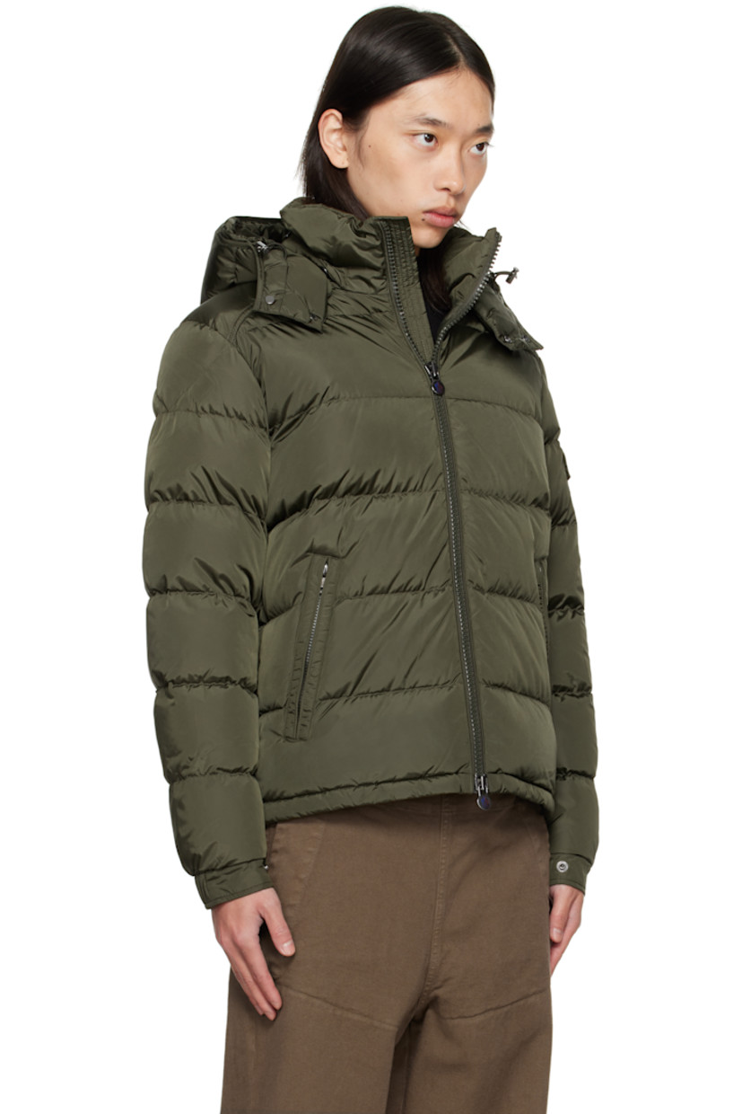 DIST-certified down-filled and quilted nylon satin jacket.

· Bungee-style drawstring at detachable hood
· Stand collar
· Two-way zip closure
· Zip pockets at front
· Bungee-style drawstring at hem
· Flap pocket and felted logo patch at sleeve
· Adjustable press-stud fastening at elasticized cuffs
· Zip pocket at interior
· Fully lined

Supplier color: Deep depths

Fill: 90% goose down, 10% feather.