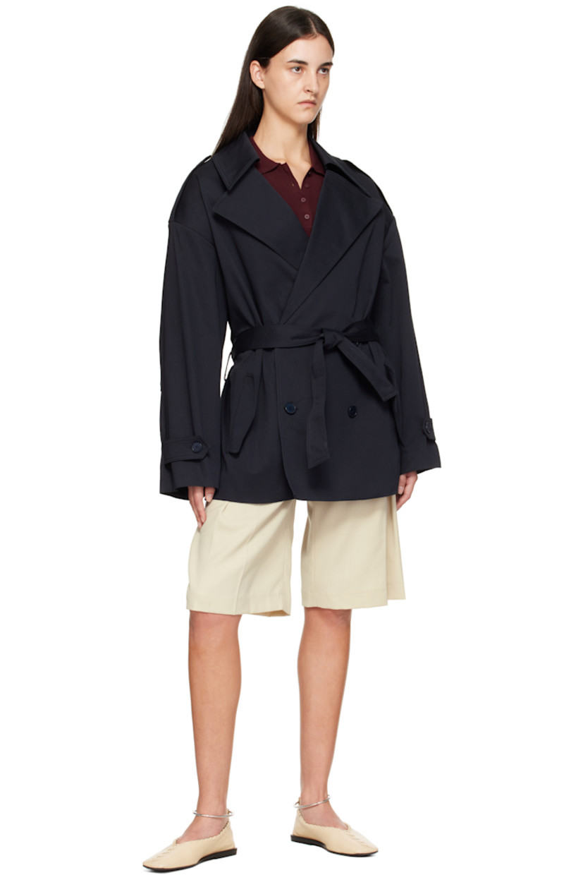 Stretch cotton gabardine trench coat.

· Notched lapel
· Double-breasted button closure
· Belt loops and detachable self-tie belt
· Flap pockets at waist
· Epaulets at padded shoulders
· Pleats at sleeves
· Button tab at cuffs
· Storm flap at back 
· Full satin lining

Supplier color: Dark navy