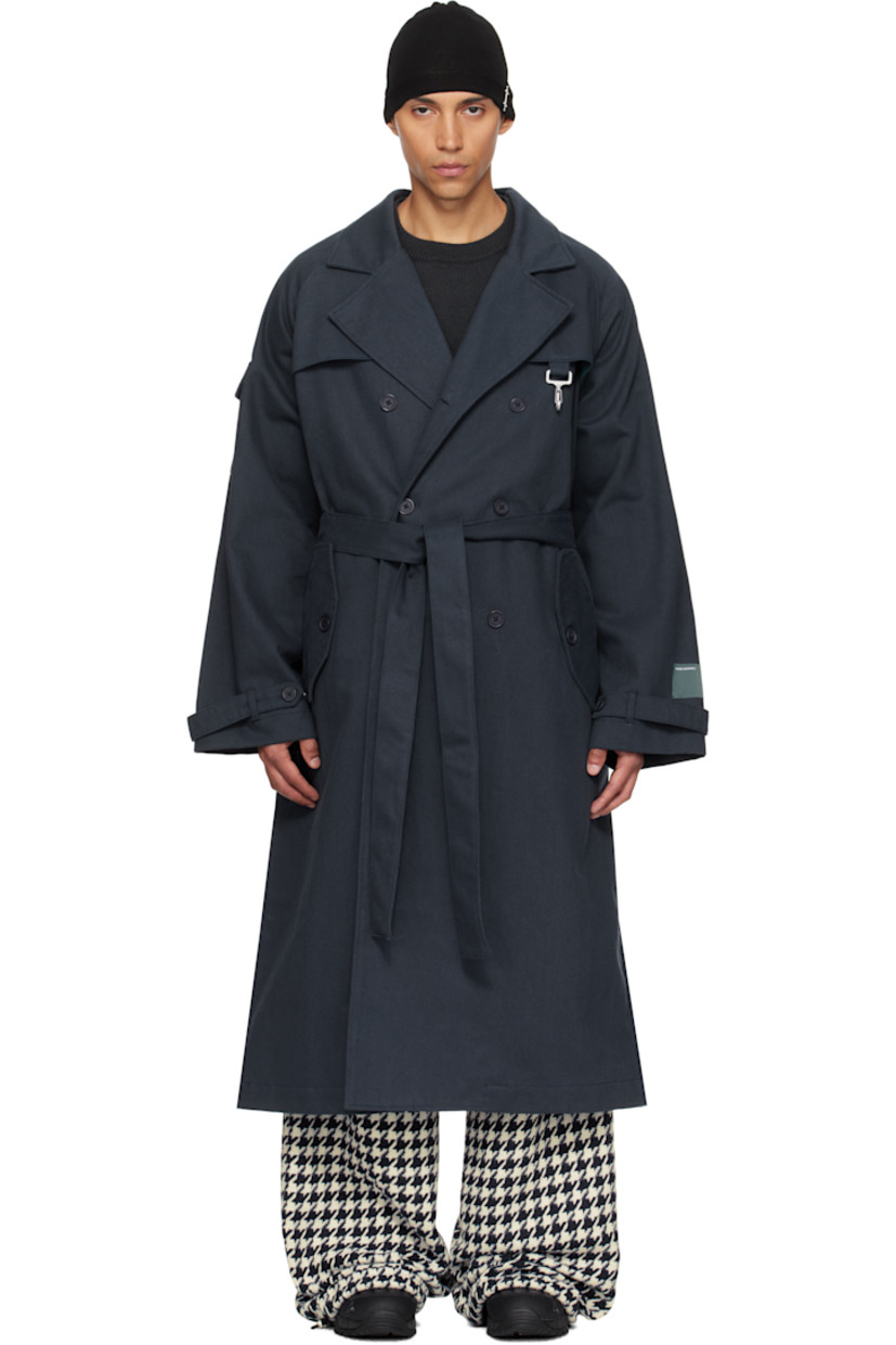 Cotton twill trench coat.

· Notched lapel
· Double-breasted button closure
· Logo-engraved clasp at chest
· Flap pockets at front and sleeve
· Belt loops and detachable self-tie belt at waist
· Raglan sleeves
· Adjustable button strap at cuffs
· Storm flap at back
· Partially lined

Supplier color: Navy